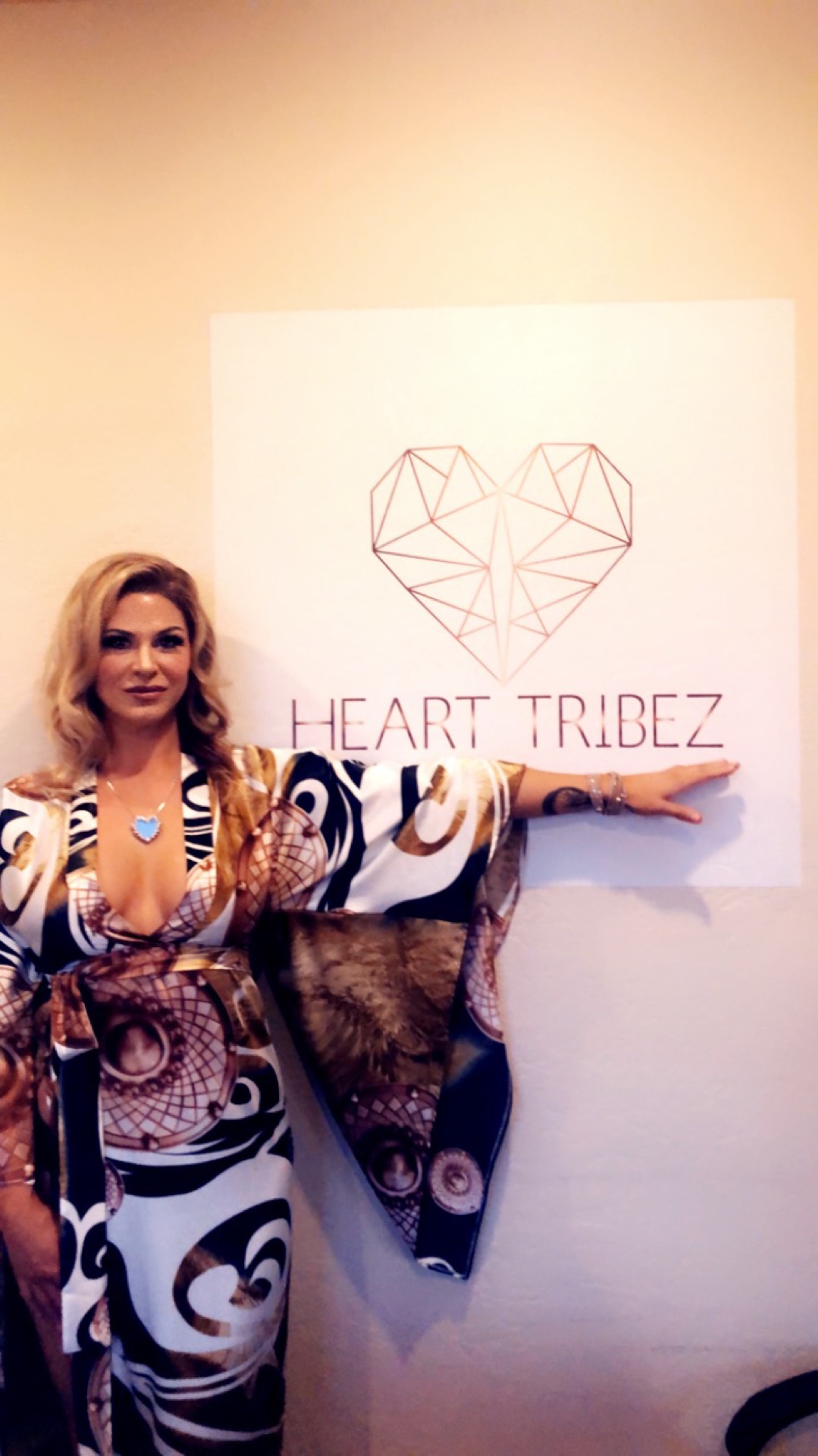 A member of Heart Tribez beside the original geometric heart logo